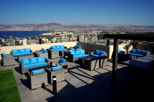 a patio with blue chairs and a view of the ocean at Baity Boutique Hotel in Aqaba
