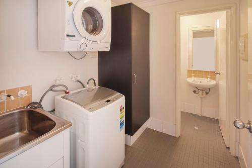 a small bathroom with a sink and a washing machine at Margs Central Stay in Margaret River Town