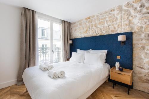 a bedroom with a large bed with towels on it at Quartier Libre - Saint Georges in Paris