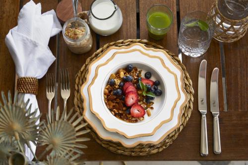 a wooden table with a bowl of cereal and fruit at Zambezi Grande Private Game Experience in Mafuta
