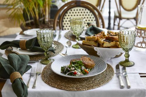 a table with a plate of food and a bowl of bread at Zambezi Grande Private Game Experience in Mafuta