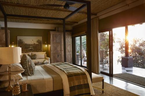 una camera da letto con un letto grande e un patio di Zambezi Grande Private Game Experience a Mafuta