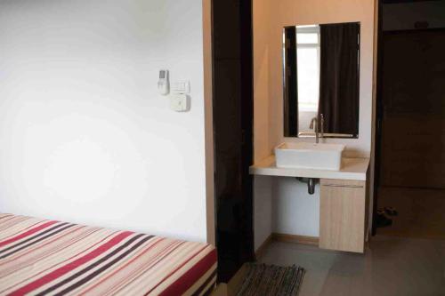 un bagno con lavandino e specchio di The C Park a Patong Beach
