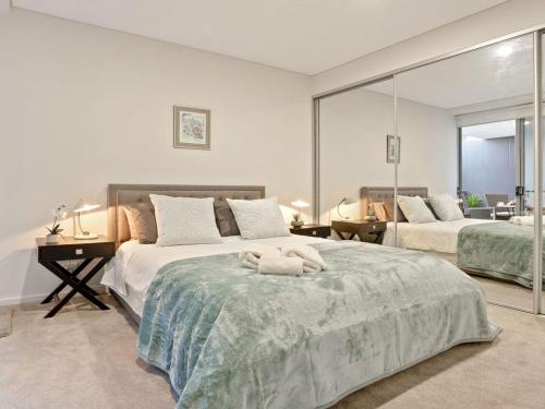 a bedroom with two beds and a large mirror at Riptide on Surf Beach in Kiama