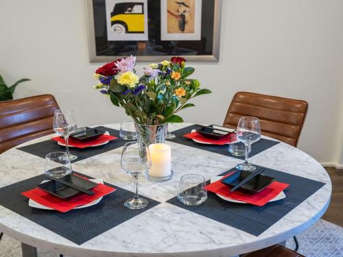 a table with a vase of flowers on top of it at Riptide on Surf Beach in Kiama