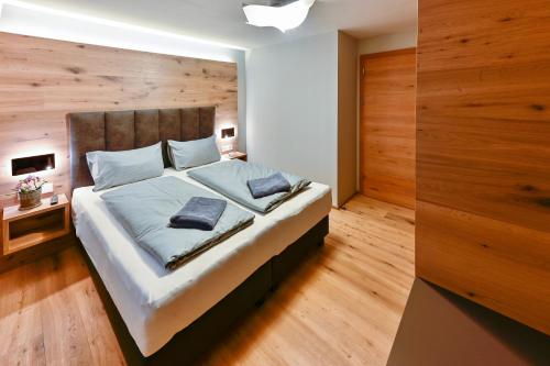a bedroom with a large bed with a wooden wall at Bergkind in Garmisch-Partenkirchen