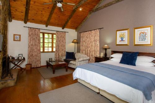 a bedroom with a large bed and a chair at Whispering Pines Country Estate in Magaliesburg