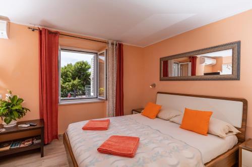 a bedroom with a bed with orange towels on it at Rooms Edna in Dubrovnik