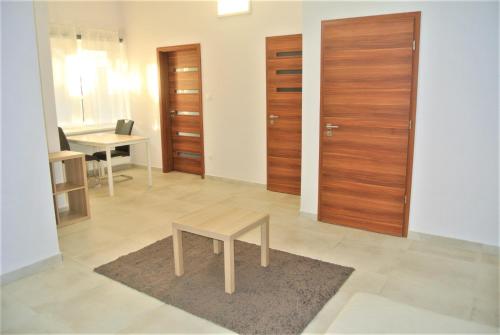 D2 Apartment Budapest في بودابست: غرفة معيشة مع طاولة وأبواب خشبية