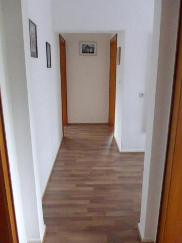an empty hallway with white walls and wood floors at Pension Schneider in Cochem