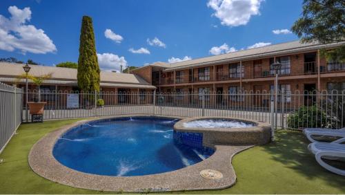 a swimming pool in front of a building at Rodney Motor Inn in Mooroopna