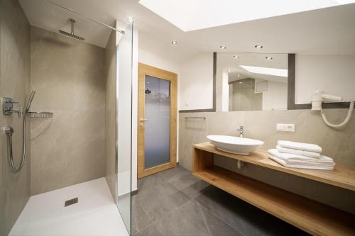 La salle de bains est pourvue d'un lavabo et d'une douche. dans l'établissement Schartnerhof Ferienwohnung Salbei, à Vols am Schlern
