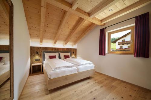 a bedroom with a bed and a window at Schartnerhof Ferienwohnung Salbei in Vols am Schlern