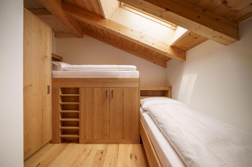 a small room with two bunk beds and a skylight at Schartnerhof Ferienwohnung Thymian in Vols am Schlern