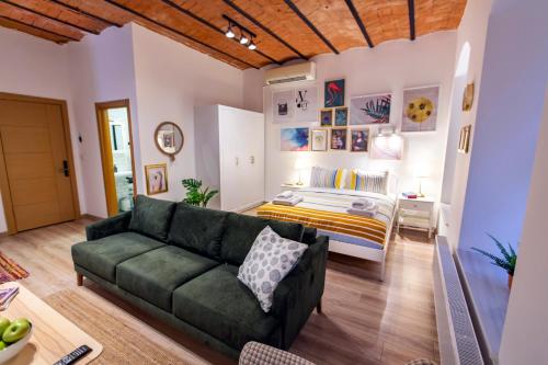 sala de estar con sofá verde y cama en Flats Company Ajda Apartment en Estambul