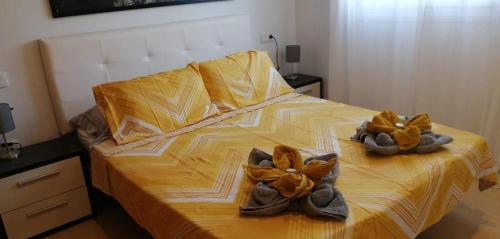 Una cama con dos pares de zapatos. en Apartment N510, Naranjos 6, Condado De Alhama, en Alhama de Murcia