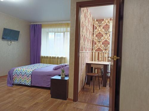 ヤロスラヴリにあるApartments on Tolbukhina 64のベッドルーム1室(ベッド1台、テーブル、窓付)
