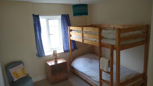 a bedroom with two bunk beds and a window at Worfield in Hereford
