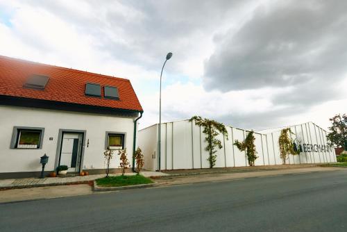 a white building with a fence next to a street at Apartment für 2 Erwachsene und 2 Kinder, ausgestattet mit einem Weinkeller und einem kleinen Hof - SELF-MADE FRÜHSTÜCK INBEGRIFFEN in Retz