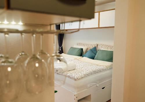 ein weißes Bett mit blauen Kissen in einem Zimmer in der Unterkunft Apartment für 2 Erwachsene und 2 Kinder mit Weinkeller und kleinem Hof mit Frühstück - Self made in Retz