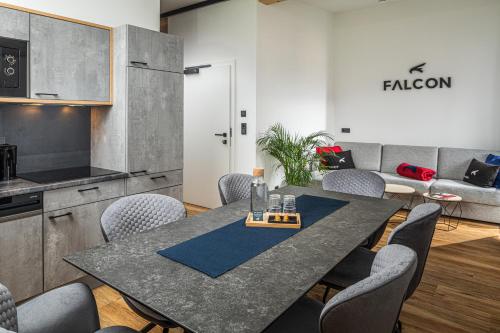 Falcon Suites Kaprun في كابرون: غرفة طعام مع طاولة وكراسي وأريكة