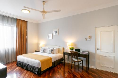 a bedroom with a bed and a desk with a chair at Wedgewood Residences in Kuala Lumpur