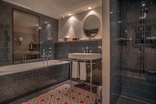 a bathroom with a tub and a sink and a mirror at La Cordée des Alpes SUP in Verbier