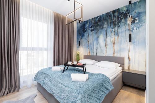 1 dormitorio con 1 cama con una pintura azul en la pared en Mogilska Apartments by Renters Prestige, en Cracovia