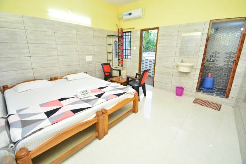 a bedroom with a bed and a table and chairs at Aryan residency in Māvalli