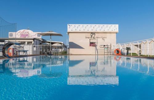 een zwembad met blauw water voor een gebouw bij Hotel Stella in Riccione