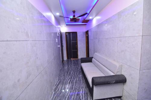 a room with a couch and a ceiling fan at Aryan residency in Māvalli