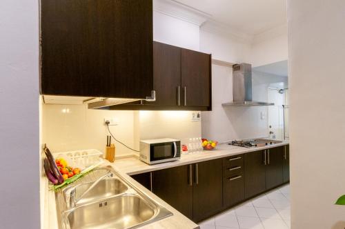 a kitchen with a sink and a microwave at Wedgewood Residences in Kuala Lumpur