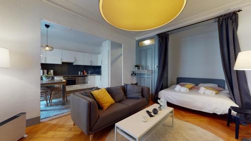 a living room with a couch and a table at Charming studio in Les Pâquis close to the famous Jet d'eau in Geneva