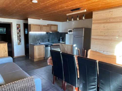 - une cuisine avec un comptoir et des chaises dans la chambre dans l'établissement Grand appartement aux SAISIES, à Hauteluce