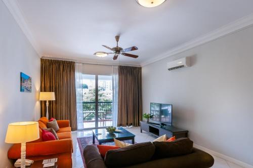a living room with two couches and a television at Wedgewood Residences in Kuala Lumpur
