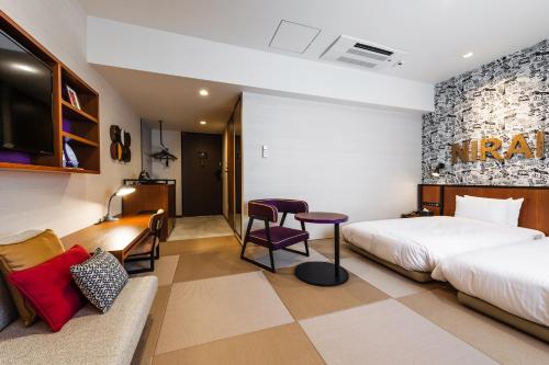 Pokój hotelowy z łóżkiem i biurkiem w obiekcie PROSTYLE RYOKAN Naha Kenchou Mae w mieście Naha