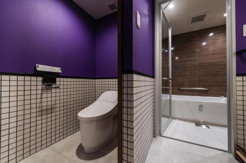 a purple bathroom with a toilet and a shower at PROSTYLE RYOKAN Naha Kenchou Mae in Naha
