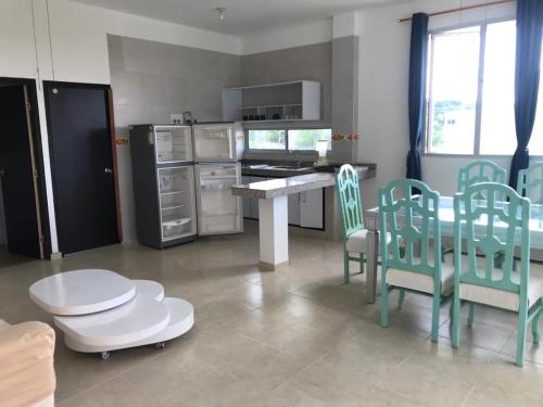 cocina con sillas verdes, mesa y barra en Villa Yalirocu, en Carretal
