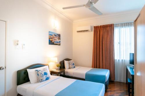Habitación de hotel con 2 camas y escritorio en Wedgewood Residences, en Kuala Lumpur