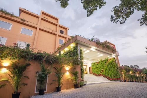 an exterior view of a building with plants at The Lalita Grand Mathura- Vrindavan in Mathura