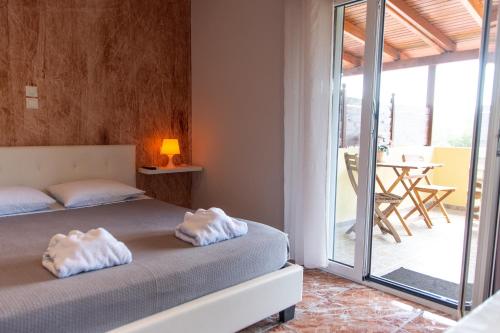 a bedroom with a bed with white towels on it at Sunset Apartments Free shuttle from Athen's Airport in Spáta