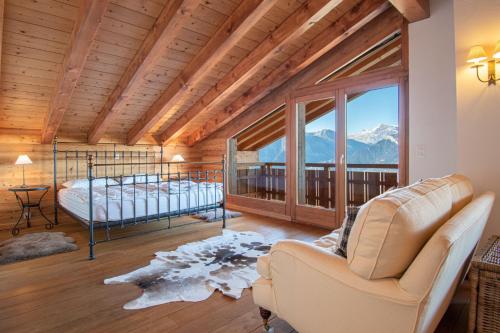 a bedroom with a bed and a balcony with mountains at Hirondelle JACUZZI & LUXURY chalet 12 pers by Alpvision Résidences in Veysonnaz