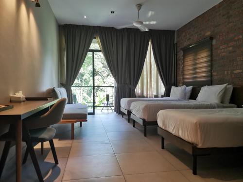 Cette chambre comprend 3 lits et un bureau. dans l'établissement Sementra Hot Spring Nature Resort, à Gopeng