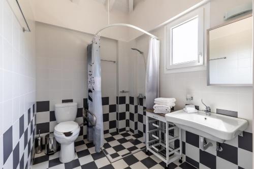 a bathroom with a black and white checkered floor at Villa Aelia by Kardous in Alikias