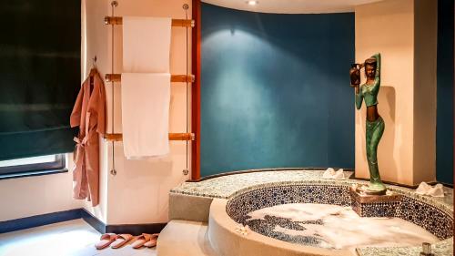 a bathroom with a sink with a woman taking a picture at Kata Beach Aspasia Boutique Apartment in Kata Beach