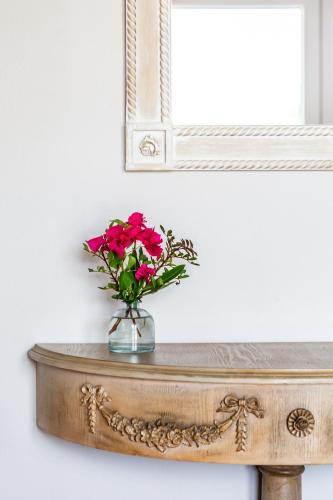 a vase of flowers on a table under a mirror at Villa Aelia by Kardous in Alikias