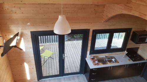 a kitchen with two windows and a pendant light at Camping Le Logis 3 étoiles in Saint-Jean-de-Monts