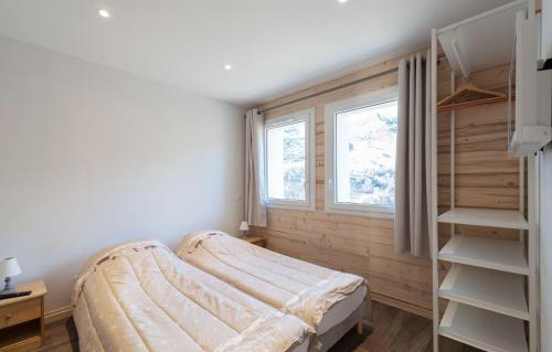 een slaapkamer met een bed en een raam bij Odalys Chalet D'Alice in Les Menuires