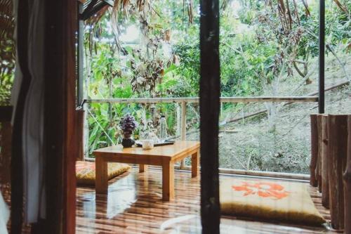 a room with a table and a large window at Baansuan Chomchun in Amphoe Mae Taeng