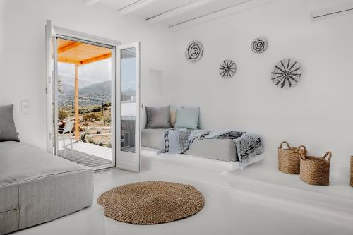 a white living room with a couch and a mirror at Xerolithos Natural Living in Naxos Chora